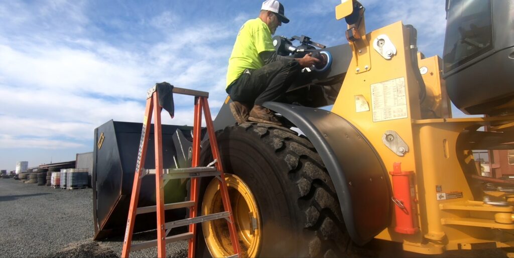 Ed Nimitz buffing arm of john deer loader